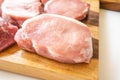 Raw pork loin chops close up on wooden cutting board on white background Royalty Free Stock Photo