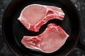 Raw Pork Loin chops in rustic skillet, pan. top view. background