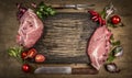 Raw pork meat chops with kitchen tools, fresh seasoning and ingredients for cooking rustic wooden background, top view, frame. Royalty Free Stock Photo