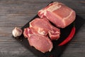 Raw pork meat. Fresh steaks on slate board on black background. Top view Royalty Free Stock Photo