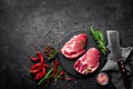 Raw pork meat. Fresh steaks on slate board on black background Royalty Free Stock Photo