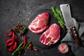 Raw pork meat. Fresh steaks on slate board on black background