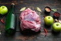 Raw pork meat and ingredients for roast, with apple dry cider, on old dark  wooden table background Royalty Free Stock Photo