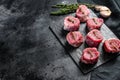 Raw pork medallion steaks with pepper and thyme. black background. Top view. Copy space Royalty Free Stock Photo