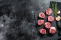Raw pork medallion steaks with pepper and thyme. black background. Top view. Copy space Royalty Free Stock Photo