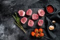 Raw pork medallion steaks with pepper and thyme. black background. Top view Royalty Free Stock Photo