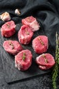 Raw pork medallion steaks with pepper and thyme. black background. Top view Royalty Free Stock Photo