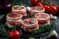 Raw pork medallion steaks wrapped in bacon served on a slate board on dark concrete background with spices salt and pepper, top Royalty Free Stock Photo