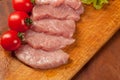 Raw pork ÃÂ¾n the wood board. Tomato and lettice Royalty Free Stock Photo