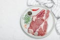 Raw pork neck meat. Chop steak, red peppercorn, garlic cloves, sea salt and fresh rosemary Royalty Free Stock Photo