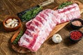 Raw pork rack spare ribs with spices, garlic cloves and thyme. Wooden background. Top view