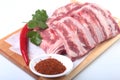 Raw pork ribs with herbs and spices on wooden board. Ready for cooking. Royalty Free Stock Photo