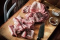 Raw pork ribs on a wooden cutting board, kitchen knife, salt, spices and towel. Royalty Free Stock Photo