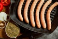 Raw pork sausages on grill pan with ingredients and spices Royalty Free Stock Photo