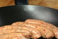 Raw pork sausages in a pan Royalty Free Stock Photo