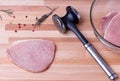 Raw pork schnitzel with meat tenderizer on wooden Royalty Free Stock Photo