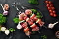 Raw pork shish kebab. BBQ meat with vegetables and spices. Top view. Free space for your text. Royalty Free Stock Photo