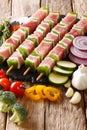 raw pork shish kebab with pepper on skewers close-up and ingredients, vegetables, herbs. vertical Royalty Free Stock Photo