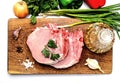 Raw pork steak, parsley, onion, garlic and pepper on old cutting board