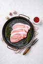 Raw pork steak ready for cooking with herbs, on white stone table background, top view flat lay Royalty Free Stock Photo