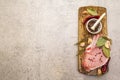 Raw pork steak with spices and dried herbs on vintage wooden board. Salt, garlic, hot pepper, rosemary, bay leaf with ceramic Royalty Free Stock Photo