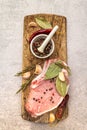 Raw pork steak with spices and dried herbs on vintage wooden board. Salt, garlic, hot pepper, rosemary, bay leaf with ceramic Royalty Free Stock Photo