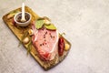 Raw pork steak with spices and dried herbs on vintage wooden board. Salt, garlic, hot pepper, rosemary, bay leaf with ceramic Royalty Free Stock Photo