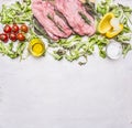 Raw pork steak on vintage cutting board lettuce, cherry tomatoes, bell pepper, oil and spices wooden rustic background top Royalty Free Stock Photo
