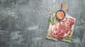 Raw pork steaks on a cutting board with spices on a dark background. place for text, top view Royalty Free Stock Photo