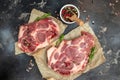 raw pork steaks on a cutting board with spices Raw meat pork steaks with seasoning. place for text, top view Royalty Free Stock Photo