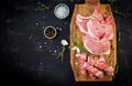 Different types of raw pork meat and chopped sausages ÃÂ¾n the dark table.