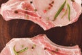 Raw pork steaks, with rosemary and pepper, on a clay plate close-up. Top view. Flat lay Royalty Free Stock Photo