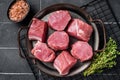 Raw pork tenderloin medallions steaks on a kitchet tray with thyme and sea salt. Black background. Top view Royalty Free Stock Photo