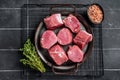 Raw pork tenderloin medallions steaks on a kitchet tray with thyme and sea salt. Black background. Top view Royalty Free Stock Photo