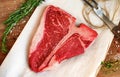 Raw porterhouse steak with herbs on a wooden Board Royalty Free Stock Photo