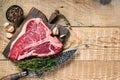 Raw Porterhouse or T-bone beef meat Steak with herbs on a wooden cutting board. wooden background. Top view. Copy space Royalty Free Stock Photo