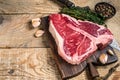 Raw Porterhouse or T-bone beef meat Steak with herbs on a wooden cutting board. wooden background. Top view. Copy space Royalty Free Stock Photo