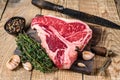 Raw Porterhouse or T-bone beef meat Steak with herbs on a wooden cutting board. wooden background. Top view Royalty Free Stock Photo