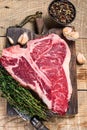 Raw Porterhouse or T-bone beef meat Steak with herbs on a wooden cutting board. wooden background. Top view Royalty Free Stock Photo