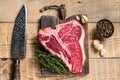 Raw Porterhouse or T-bone beef meat Steak with herbs on a wooden cutting board. wooden background. Top view Royalty Free Stock Photo