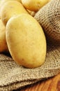 Raw potatoes in jute sack, closeup