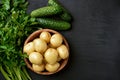 Raw potatoes, parsley and cucumbers on dark background Royalty Free Stock Photo