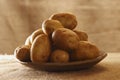 Raw potatoes on plate with burlap rustic