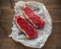 Raw premium beef sirloin steak with thyme and papper corn and sea salt seasoning drizzled with olive oil on cooking Royalty Free Stock Photo