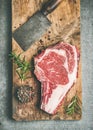 Raw prime beef meat dry-aged steak rib-eye and chopping knife Royalty Free Stock Photo