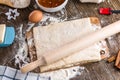 Raw puff pastry and rolling pin on a cutting wooden board Royalty Free Stock Photo