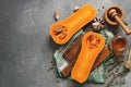 Raw pumpkin halves or butternut squash, cutting board, herbs, honey on a gray background. Top view, flat lay, copy space