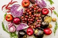 Raw purple and red vegetables and fruit on white marble background top view