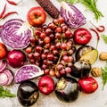 Raw purple and red vegetables and fruit on white marble background top view