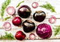 Raw purple vegetables on white wooden background top view